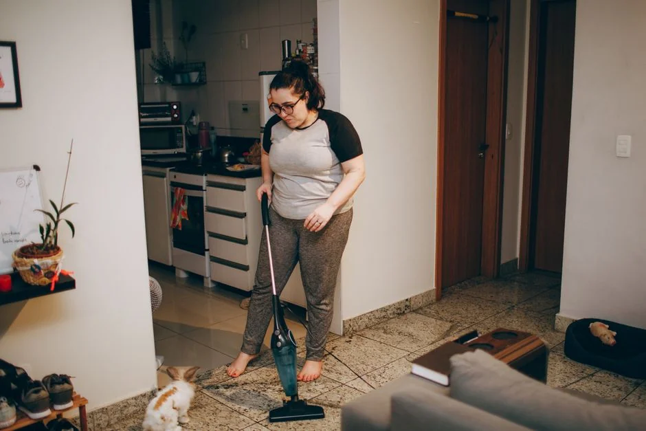 Asian couple having fun while cleaning their home, enhancing a cheerful atmosphere.